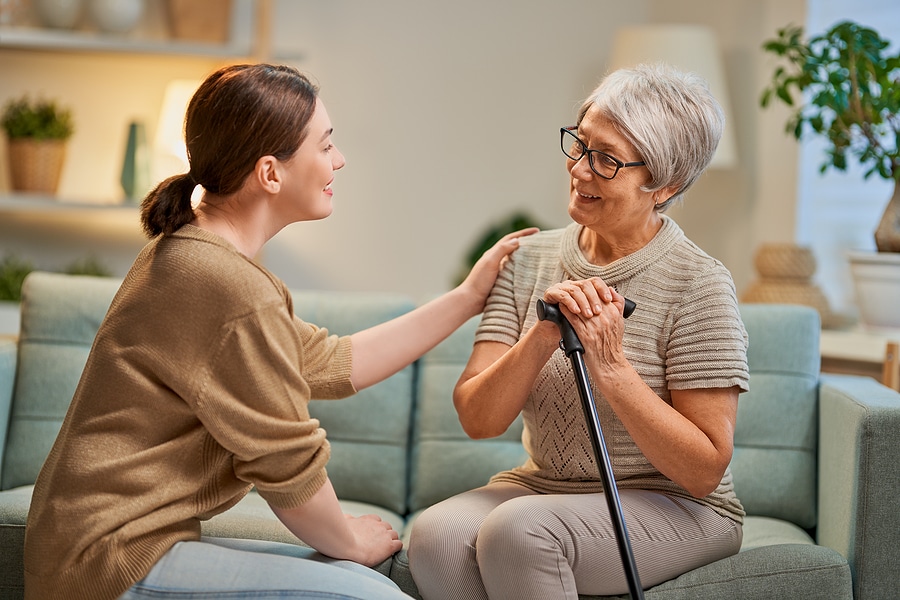 Senior woman with dementia visiting with her adult caregiver.