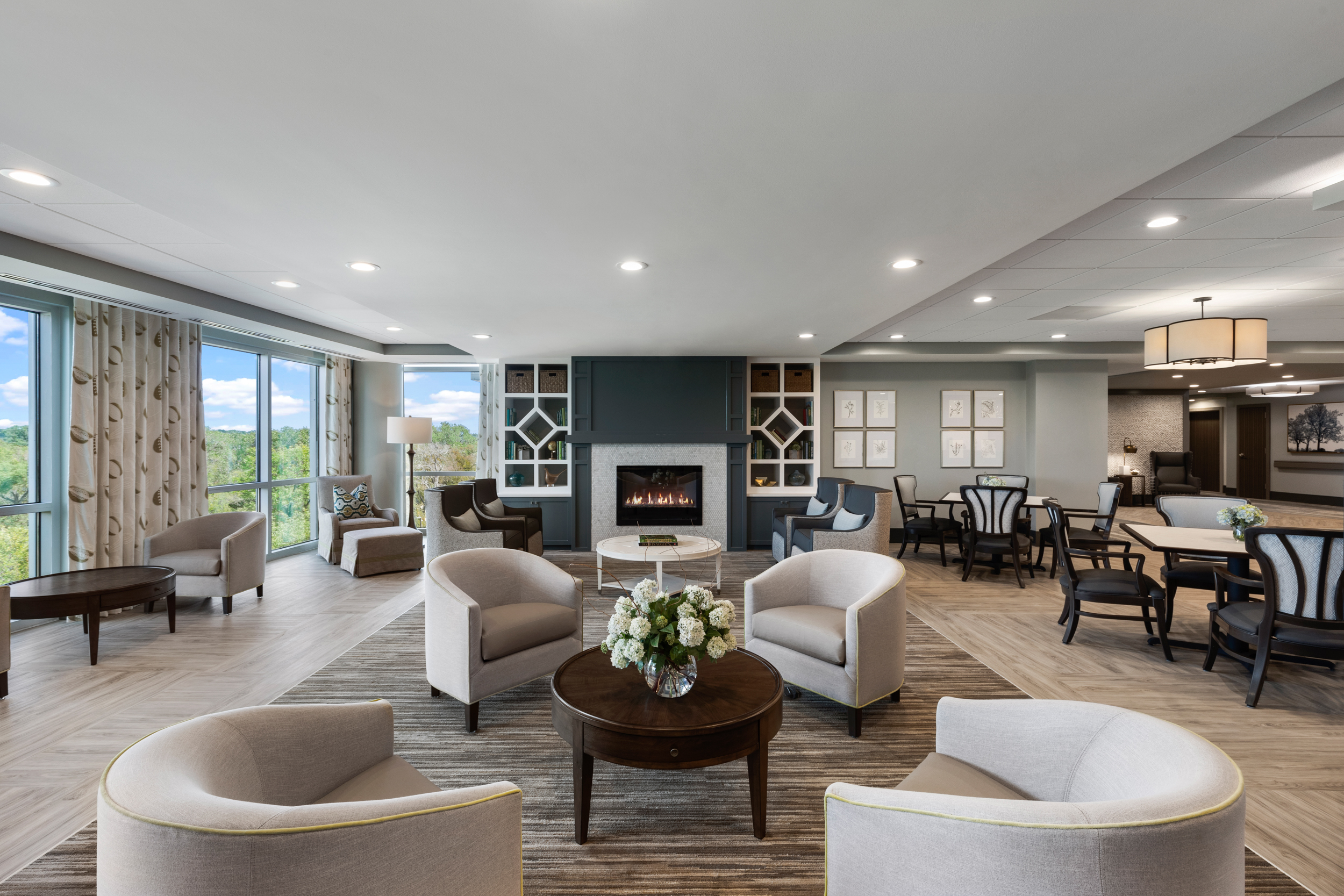 4th floor inside the vista featuring a fireplace, chairs and tables